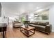 Open living room with hardwood floors, neutral furnishings, and seamless flow to the kitchen at 5914 S Kearney St, Centennial, CO 80111