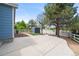 Landscaped backyard with a shed, mature trees, and concrete patio at 1118 S Duquesne Cir, Aurora, CO 80018
