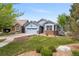 Beautiful blue home with green lawn, brick details, landscaped yard, and neighborhood view at 1118 S Duquesne Cir, Aurora, CO 80018