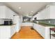 Bright kitchen with white cabinets, green countertops, tile backsplash, and hardwood floors at 1118 S Duquesne Cir, Aurora, CO 80018