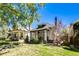 Street view of quaint bungalow featuring a cozy front porch, set amidst a lush green lawn and mature trees at 284 S Lafayette St, Denver, CO 80209