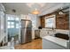 Bright kitchen featuring stainless steel appliances, white cabinetry, exposed brick wall, and stylish light fixture at 284 S Lafayette St, Denver, CO 80209