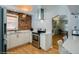 Modern kitchen with stainless steel appliances, white cabinets, exposed brick, and an open layout leading to living area at 284 S Lafayette St, Denver, CO 80209