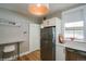 Inviting kitchen featuring stainless steel refrigerator, white cabinets, and stylish light fixture at 284 S Lafayette St, Denver, CO 80209