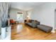 Sunlit living room with hardwood floors and a gray sofa topped with orange throw pillows for a warm ambiance at 284 S Lafayette St, Denver, CO 80209