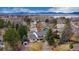 Aerial view shows a home with a manicured yard and mature trees near a park with a lake at 8510 Independence Way, Arvada, CO 80005