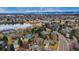 Aerial view shows houses next to a lake, a park with tennis courts and a partially cloudy sky at 8510 Independence Way, Arvada, CO 80005
