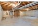 Unfinished basement with concrete floor and exposed wood ceiling beams, ready for customization at 8510 Independence Way, Arvada, CO 80005