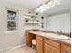 Bright bathroom featuring a vanity with a sink, a large mirror, and open shelving at 8510 Independence Way, Arvada, CO 80005