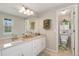 Bathroom featuring double sinks, large mirrors, and an adjacent toilet room at 8510 Independence Way, Arvada, CO 80005