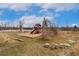 Community playground with slide and tree trunk seating located near walking path and lake at 8510 Independence Way, Arvada, CO 80005