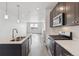 Gourmet kitchen featuring stainless steel appliances, dark cabinets, and a large kitchen island at 453 Interlocken Blvd # 103, Broomfield, CO 80021