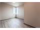 Small bedroom with large window and wood-look floors at 12983 W Ida Ave # 401, Littleton, CO 80127