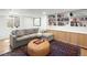 Finished basement featuring a gray sofa, ottoman, built-in shelving and cabinets at 1842 S Fairfax St, Denver, CO 80222