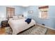 Serene bedroom featuring light blue walls, hardwood floors, a cozy rug, and natural light from two windows at 1842 S Fairfax St, Denver, CO 80222