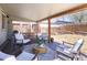 Relaxing covered patio featuring cozy armchairs, an outdoor dining set, and tranquil backyard views at 1842 S Fairfax St, Denver, CO 80222