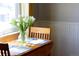 Bright dining area featuring a vase of white tulips on a wooden table by a sunlit window at 1842 S Fairfax St, Denver, CO 80222