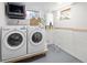 Bright laundry room with washer, dryer, hanging rack and window at 1842 S Fairfax St, Denver, CO 80222