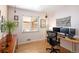 Home office featuring hardwood floors, dual monitors, a large window, and unique decor at 1842 S Fairfax St, Denver, CO 80222