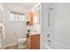 Bright bathroom features a white shower and bathtub combination, sink, and a frosted window at 3276 S Osceola St, Denver, CO 80236