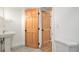 Bathroom view with a pedestal sink, toilet, and adjacent paneled doors at 3276 S Osceola St, Denver, CO 80236