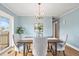 Dining room with a modern chandelier, hardwood floors, and a sliding door to the patio at 3276 S Osceola St, Denver, CO 80236