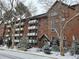 Well-maintained brick apartment building with balconies and snow-covered grounds at 1270 N Marion St # 103, Denver, CO 80218