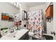 Cozy bathroom with a patterned shower curtain, vanity, and decorative storage at 2428 W 82Nd Pl # 2D, Westminster, CO 80031