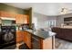 Open-concept kitchen flowing into a living area, featuring wood cabinets and stainless steel appliances at 2428 W 82Nd Pl # 2D, Westminster, CO 80031