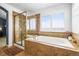 Elegant bathroom showcasing a tub, a separate glass-enclosed shower, and a bright window for natural light and ventilation at 743 Briar Haven Dr, Castle Pines, CO 80108