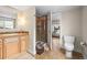 Bathroom with earth-toned tile floors, wood vanity, glass shower, and toilet at 743 Briar Haven Dr, Castle Pines, CO 80108