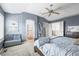 Comfortable bedroom with blue accent wall, ceiling fan and view to ensuite bath and walk-in closet for ample storage at 743 Briar Haven Dr, Castle Pines, CO 80108
