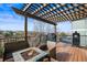 Relaxing outdoor deck features a fire pit, comfortable seating, and a pergola at 743 Briar Haven Dr, Castle Pines, CO 80108