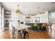 Bright, airy kitchen features a large island with bar seating, modern pendant lighting, and hardwood floors at 743 Briar Haven Dr, Castle Pines, CO 80108