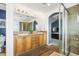 Bathroom featuring double vanity, walk-in shower, tiled floors, and access to main bedroom at 743 Briar Haven Dr, Castle Pines, CO 80108