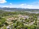 Scenic aerial view showcasing neighborhood homes nestled among lush trees and scenic lakes against a mountain backdrop at 3030 Alkire St, Golden, CO 80401