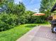 Spacious backyard with a shaded patio featuring an umbrella and grill, ideal for outdoor gatherings and relaxation at 3030 Alkire St, Golden, CO 80401