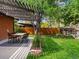 Outdoor dining area with pergola, complemented by a lush green lawn and mature trees, perfect for entertaining at 3030 Alkire St, Golden, CO 80401