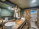 Rustic bathroom featuring double sinks, wooden accents, modern fixtures, and a barn door at 3030 Alkire St, Golden, CO 80401