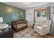Well-lit Bedroom featuring a wooden crib, white rocking chair, and neutral decor at 3030 Alkire St, Golden, CO 80401