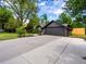 Spacious driveway leading to a well maintained house with an attached garage and mature trees at 3030 Alkire St, Golden, CO 80401