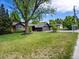 Well-maintained home with an attached garage, lush lawn, and mature trees providing ample shade at 3030 Alkire St, Golden, CO 80401
