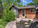 Inviting front entrance with a brick facade, a storm door, and beautiful landscaping at 3030 Alkire St, Golden, CO 80401