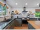 Contemporary kitchen featuring stainless steel appliances, granite countertops and custom vent hood at 3030 Alkire St, Golden, CO 80401