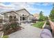 Spacious backyard with a stone patio, mature landscaping, and an outdoor dining area at 13942 W 87Th Dr, Arvada, CO 80005