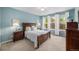 Serene bedroom with large windows, white curtains, and hardwood furniture at 13942 W 87Th Dr, Arvada, CO 80005