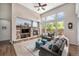 Bright living room featuring a stone fireplace, high ceilings, and large windows with scenic views at 13942 W 87Th Dr, Arvada, CO 80005