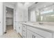 Bright bathroom featuring double vanity, quartz countertop, and a glass-enclosed shower at 16517 W 92Nd Pl, Arvada, CO 80007