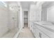 Bright bathroom featuring a glass shower and double vanity at 16517 W 92Nd Pl, Arvada, CO 80007