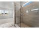 A view of the glass shower showcasing a tiled interior and light-filled transom window at 16517 W 92Nd Pl, Arvada, CO 80007